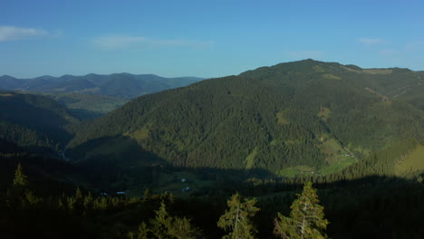aerial mountain valley village view with charming green rocky peaks blue sky