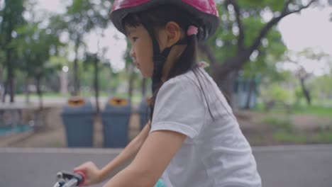 young girl riding bicycle in a park