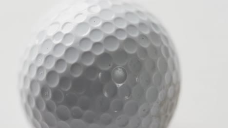 Nahaufnahme-Eines-Golfballs-Auf-Weißem-Hintergrund,-Zeitlupe,-Kopierraum