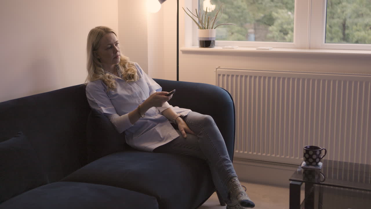 Kvinde ser fjernsyn i stuen