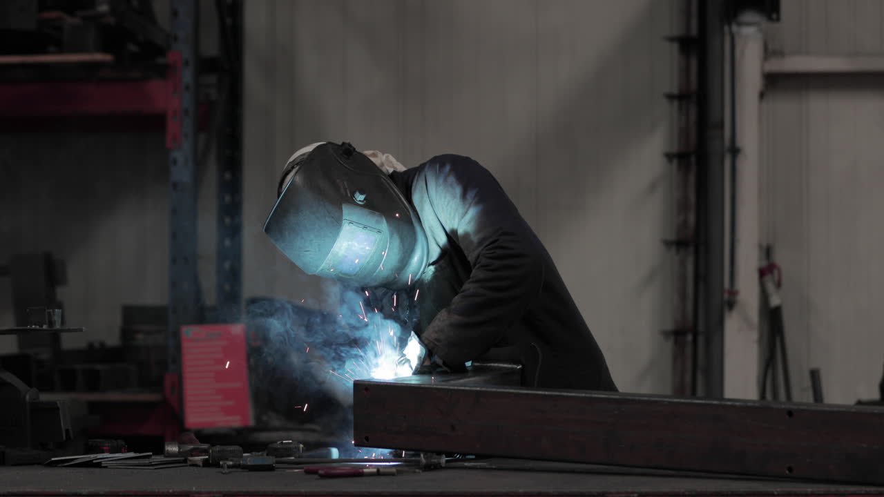 Factory Worker Skillfully Welding Metal - slow motion medium shot