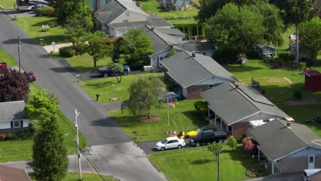 a drone tilts up over a street of suburban homes in small town in america