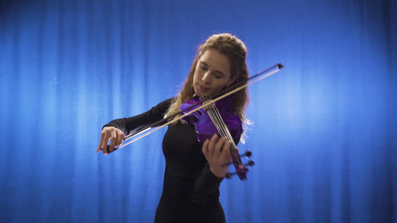 música inspiradora mujer talentosa tocando el violín en el escenario y feliz.