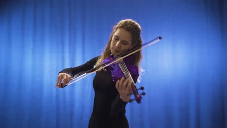 inspirational talented musician woman playing violin on stage and happy.