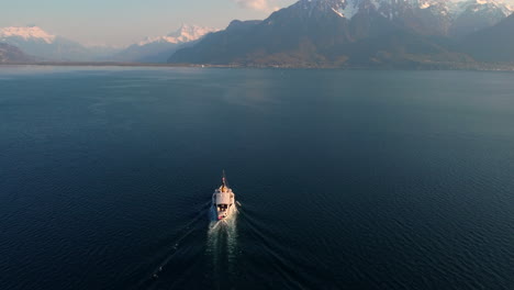 Drone's-flight-over-the-Leman-Lake-from-Vevey,-featuring-the-Ferry-boat-going-to-the-French-border-and-aiming-at-the-mountains