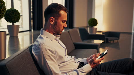 man using a tablet while sitting on a couch