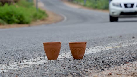 thé chaud servi dans une tasse d'argile de poterie traditionnelle sans poignée avec un paysage de route flou