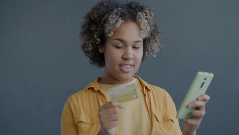 young woman using smartphone and credit card