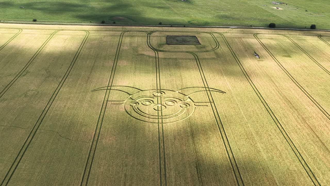 Cloud shadows passing Wiltshire jester crop circle aerial view of golden rural wheat farmland field