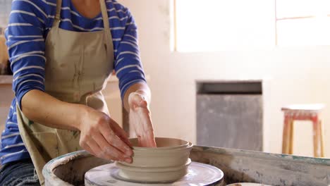 female potter making a pot