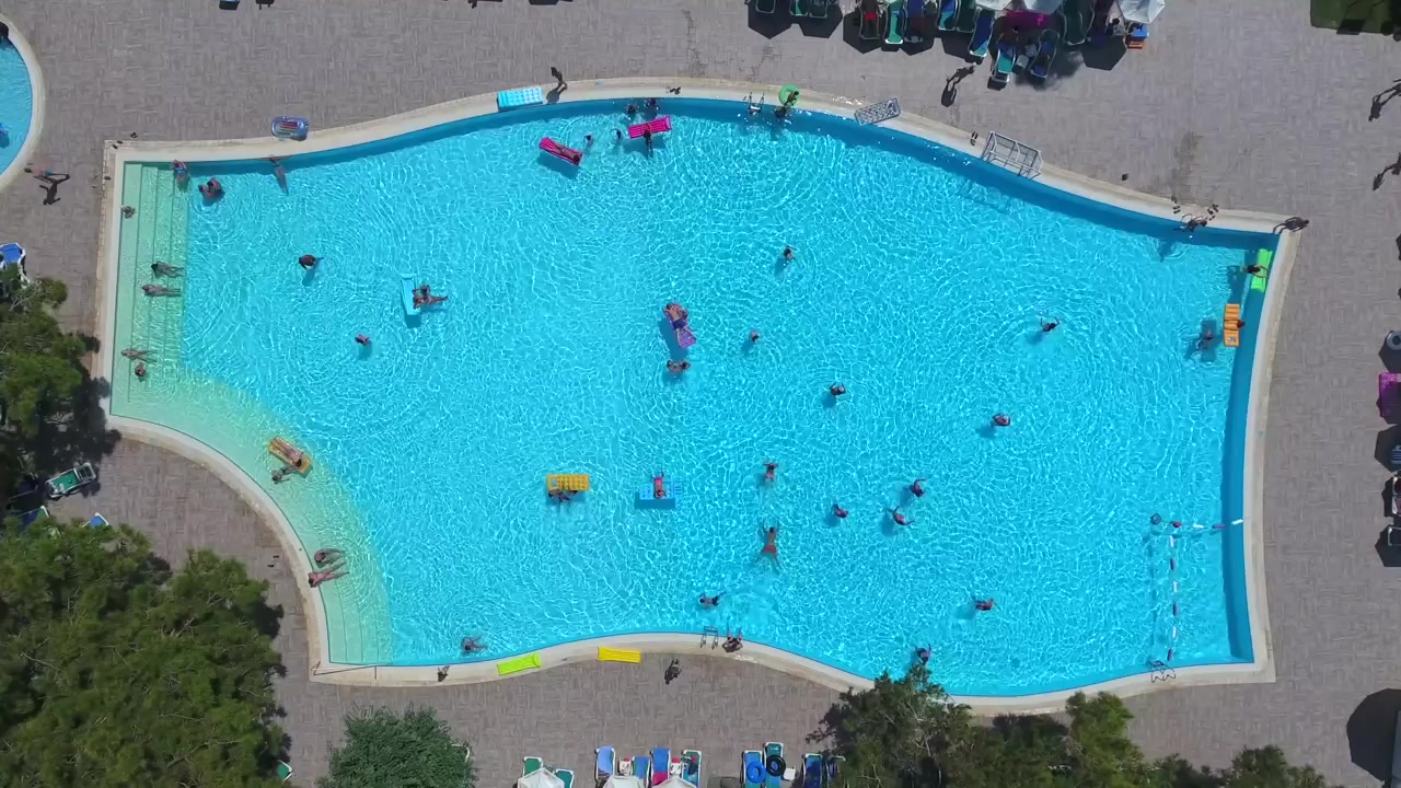Vista Aérea de Pessoas Nadando em uma Grande Piscina de Resort