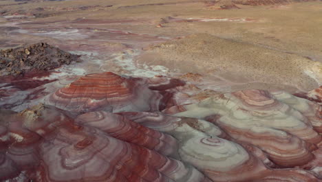 Drone-aerial-view-footage-of-man-standing-in-the-colourful-rock-formations-at-Mars-desert-research-station-in-Utah,-United-States