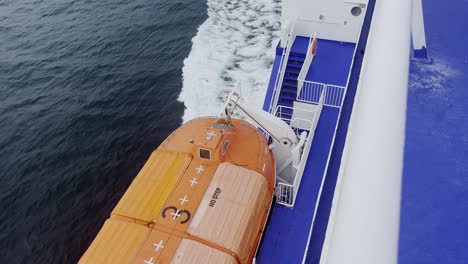 Bote-Salvavidas-Naranja-En-Un-Ferry-Flotando-En-El-Mar-Con-Barandillas-Azules-Y-Blancas-En-El-Camino-A-Suecia-En-Europa