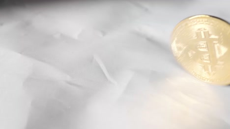 hand spinning solid gold bitcoin until it stops on white background