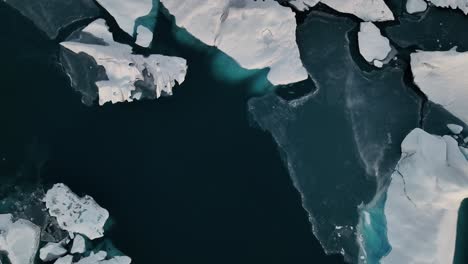 bird's eye view over jokulsarlon glacier lagoon with floating icebergs in south iceland - drone shot