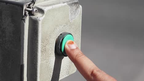 botón de empuje verde en una caja de metal