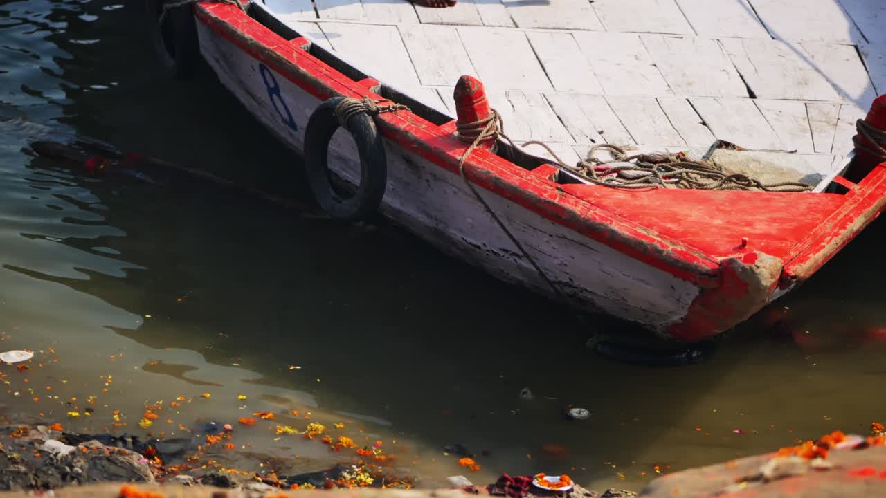 Boat parking at river port in ganga river with flowers at banaras, varanasi, kashi, uttar pradesh, india. day time, stable shot, 4k.