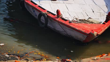 boat parking at river port in ganga river with flowers at banaras, varanasi, kashi, uttar pradesh, india. day time, stable shot, 4k.