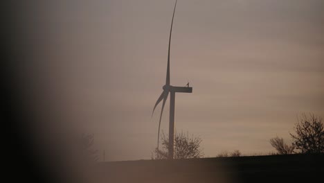 Windrad-Dreht-Sich-Bei-Sonnenuntergang-Mit-Einem-Ruhigen,-Heiteren-Himmel-Im-Hintergrund