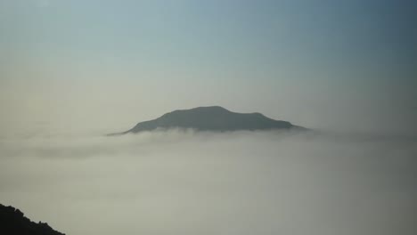 천천히 움직이는 구름으로 둘러싸인 산꼭대기