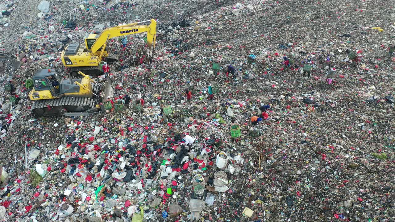 vertedero de basura con trabajadores y maquinaria