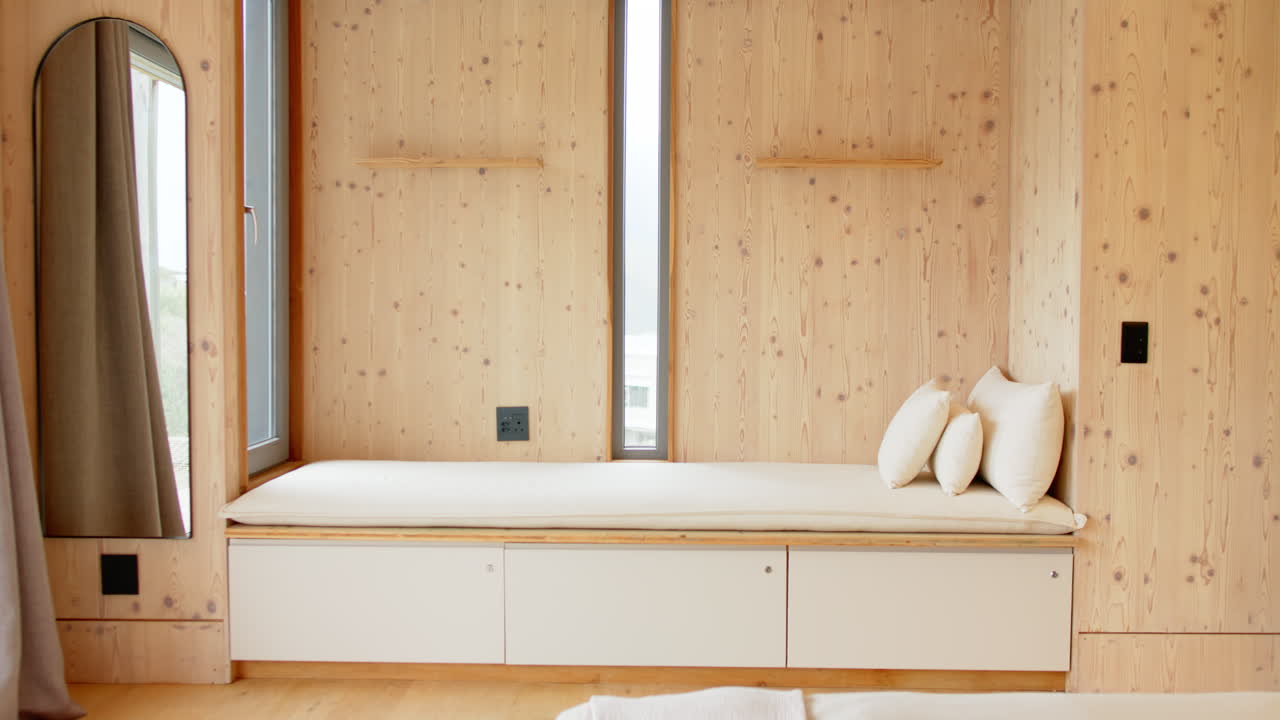 Cozy wooden nook with cushions and natural light in modern home, copy space