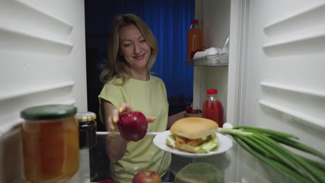 woman looking in fridge at night
