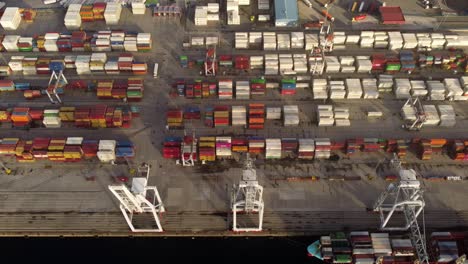 Port-full-of-stacked-shipping-containers-handled-by-cranes