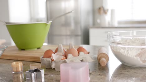 close up of baking tools, bowls and ingredients on countertop in kitchen