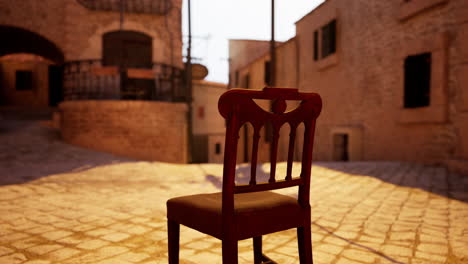 una silla solitaria en una calle de adoquines en un pueblo medieval