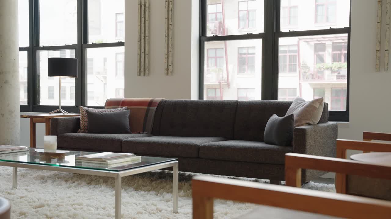 현대적인 고급 주택의 밝은 거실에 있는 짙은 갈색 소파 또는 소파