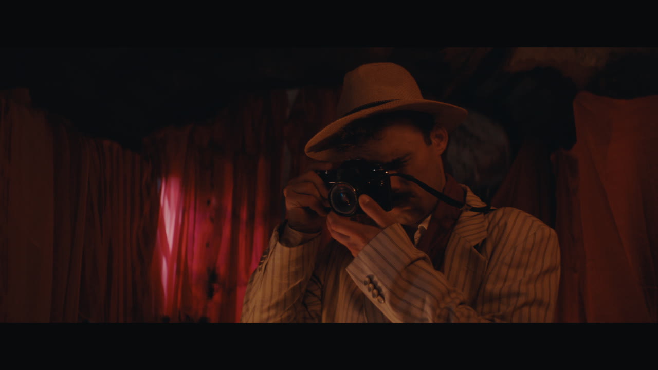 A man in hat takes a photo inside the circus cart