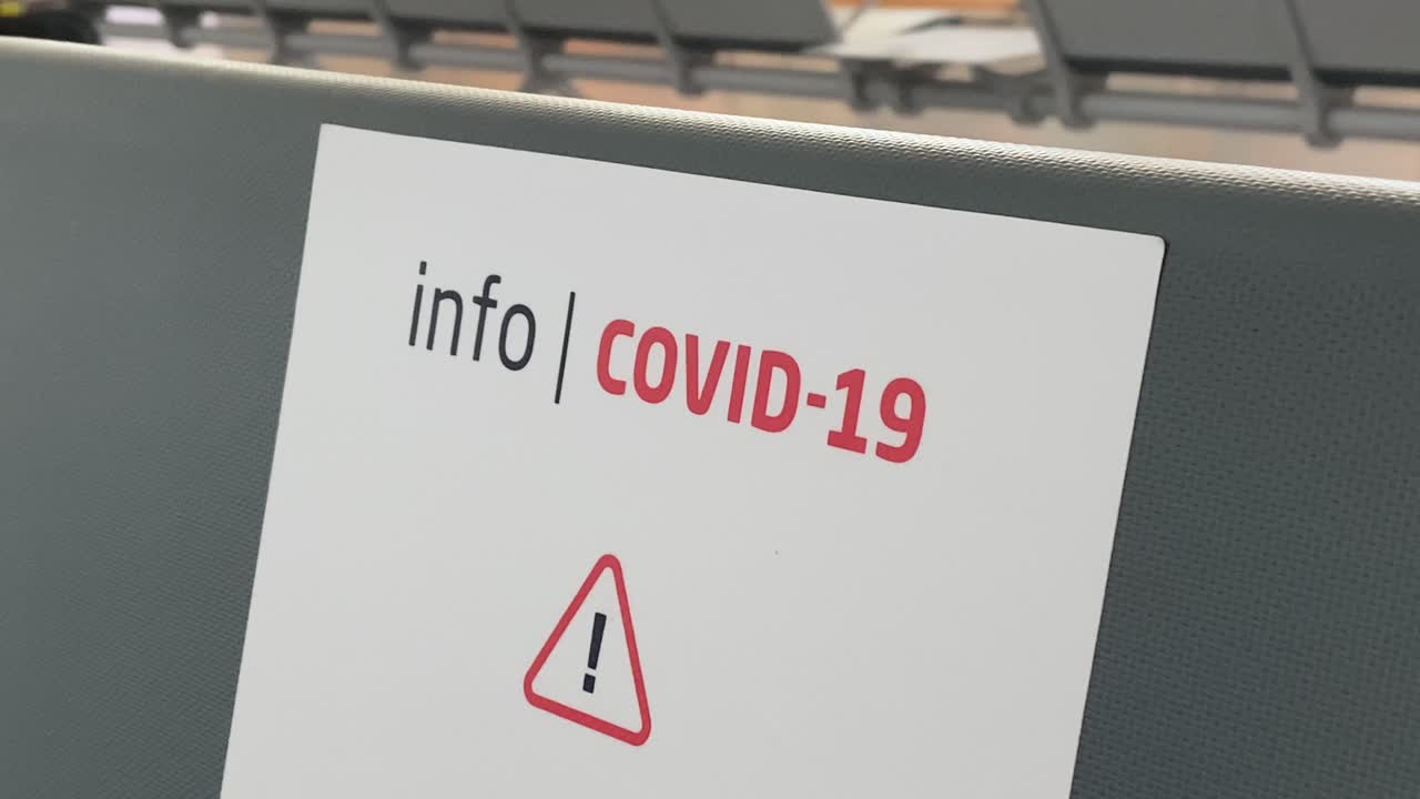Cartello informativo sul Coronavirus su un sedile di un aeroporto