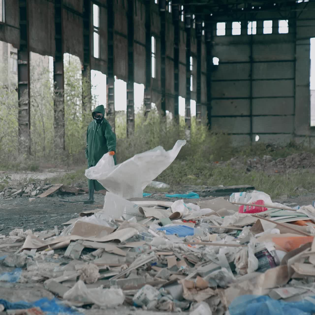 Man in chemically protective clothing. Human in gas mask walking among ruins