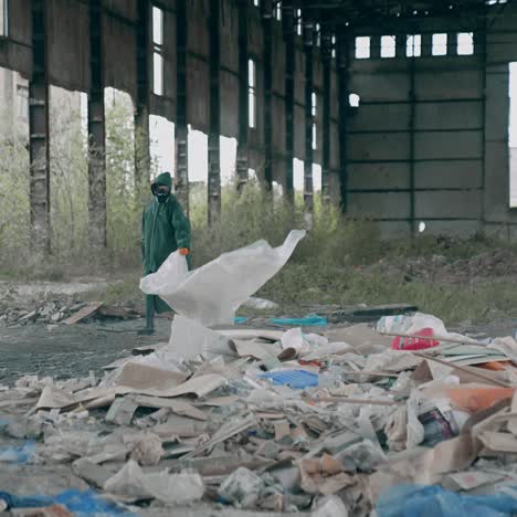 man in chemically protective clothing. human in gas mask walking among ruins