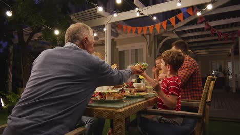 Three-generation-family-enjoying-lunch-outdoors