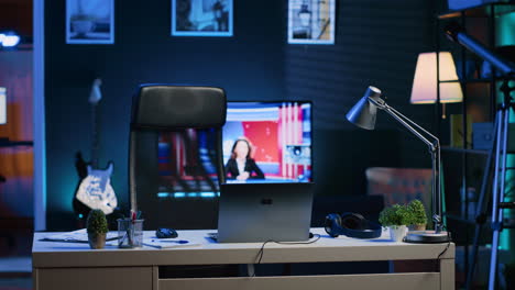 home office desk in front of smart tv displaying news program broadcasting