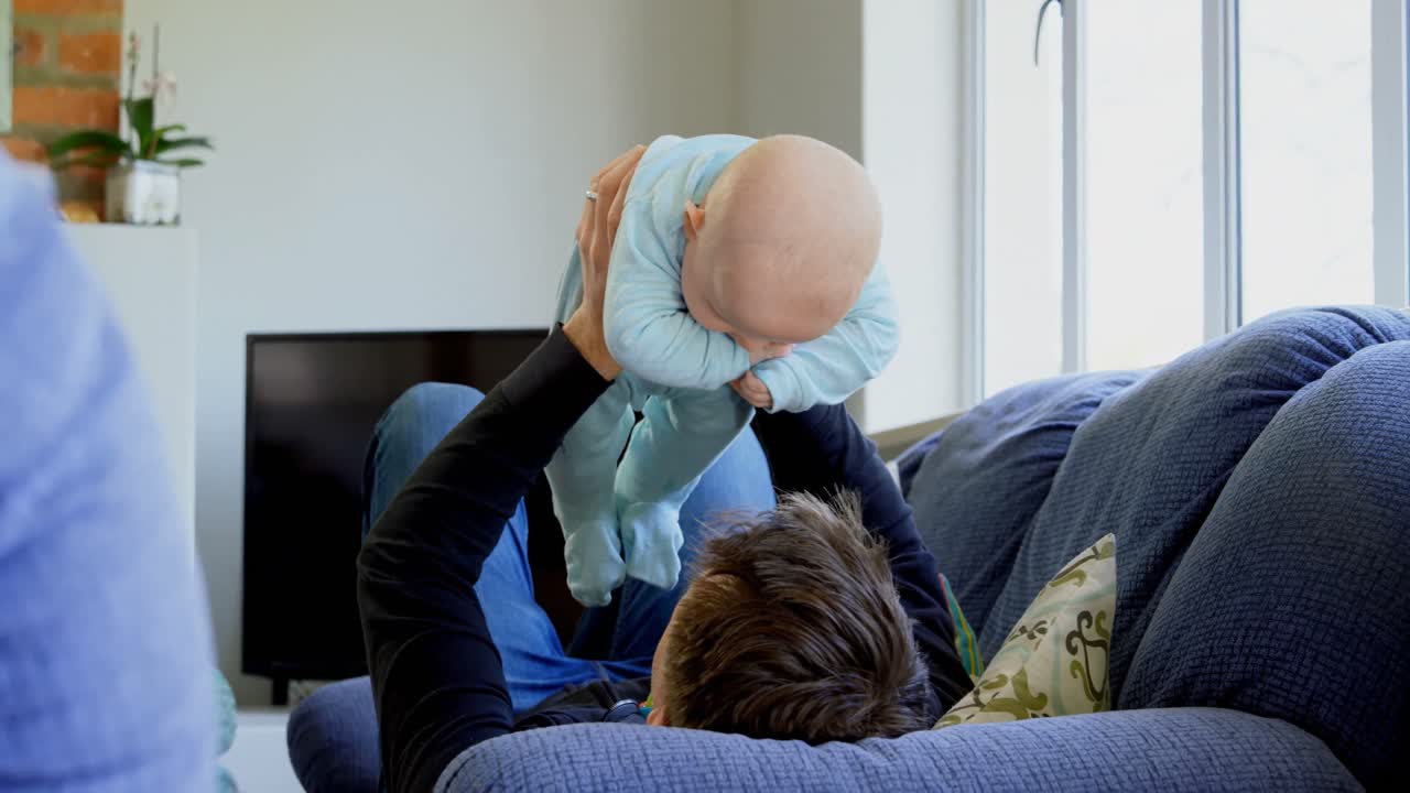 padre jugando con su bebé en la sala de estar 4k