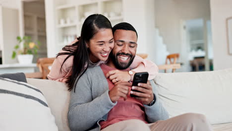 Couple,-hug-and-laugh-on-sofa-with-smartphone