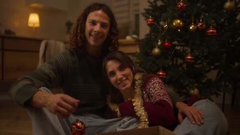 pareja decorando el árbol de navidad