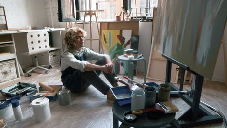 artist sitting in front of painting