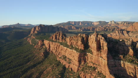 aerial pan right of expansive, orange utah mountains and valleys showing impressive and rugged landscapes of the american southwest