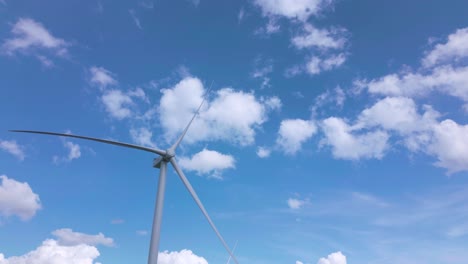 aerial approaching motionless wind turbine on sunny day