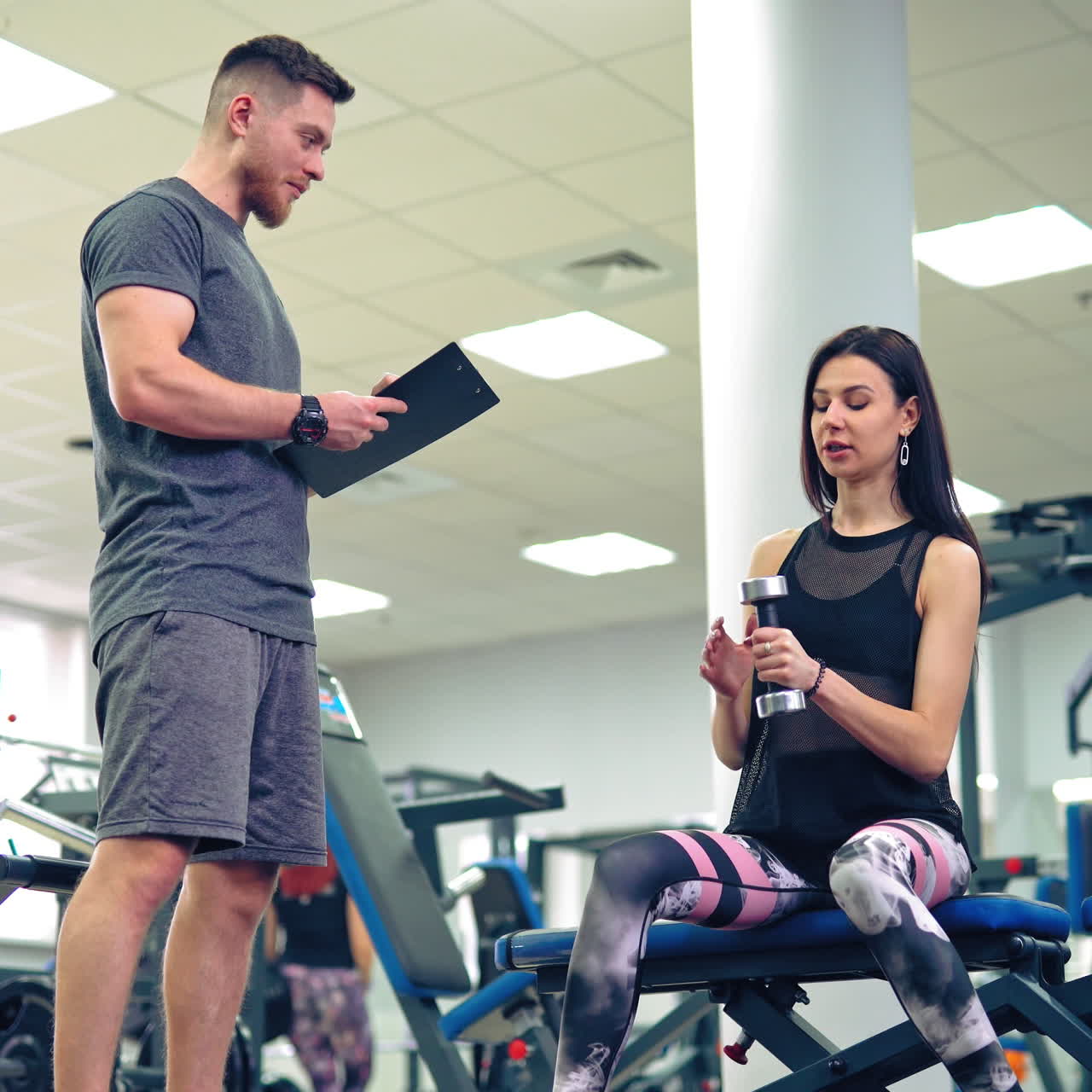 Personal trainer working with his client in gym. Personal fitness instructor.
