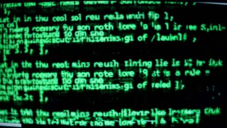 close-up video of a computer screen displaying green text on a black background, angled slightly