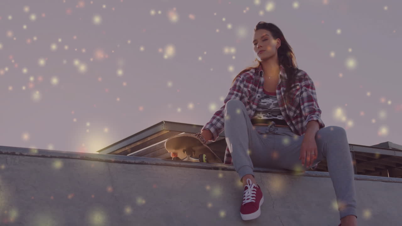 woman sitting on concrete skate ramp at dusk, holding skateboard, showing glowing marketing charts