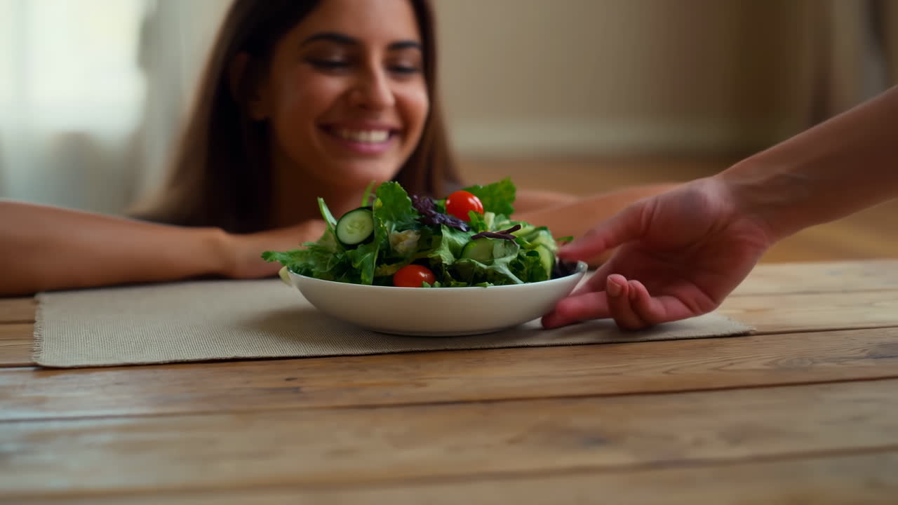 Giovane donna felice riceve un'insalata verde fresca.