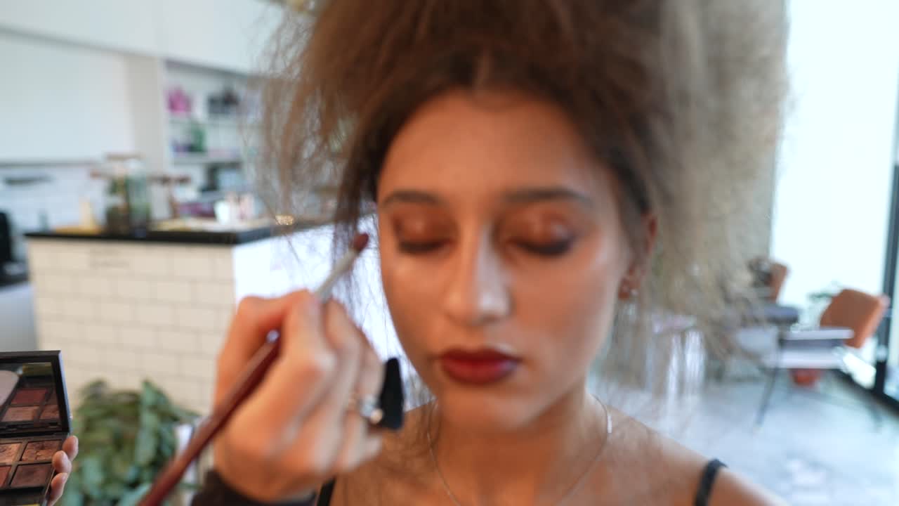 Makeup Artist Applying Eyeshadow to a Woman's Eyelids