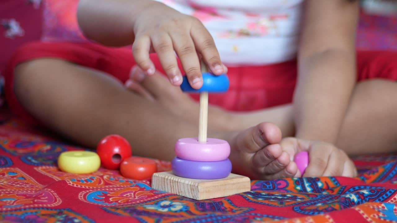 Niño jugando con juguetes de bebé en la cama, concepto de desarrollo infantil