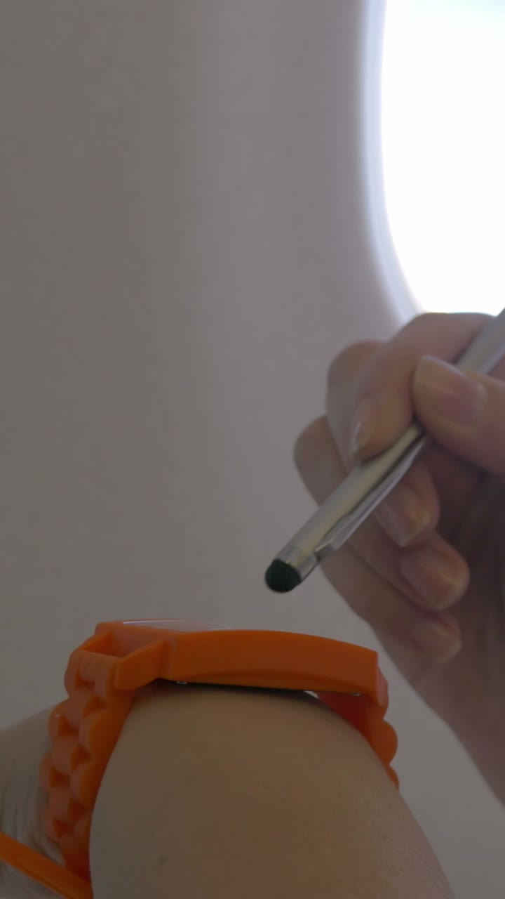 Close-up of wrist with wearable and stylus